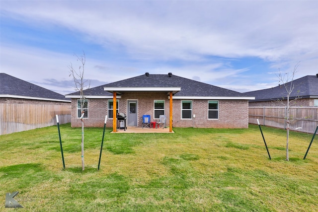 rear view of house with a patio, brick siding, and a fenced backyard