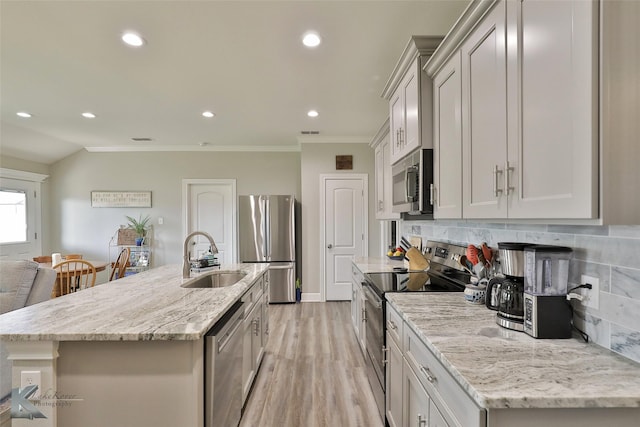 kitchen featuring a sink, ornamental molding, backsplash, and stainless steel appliances