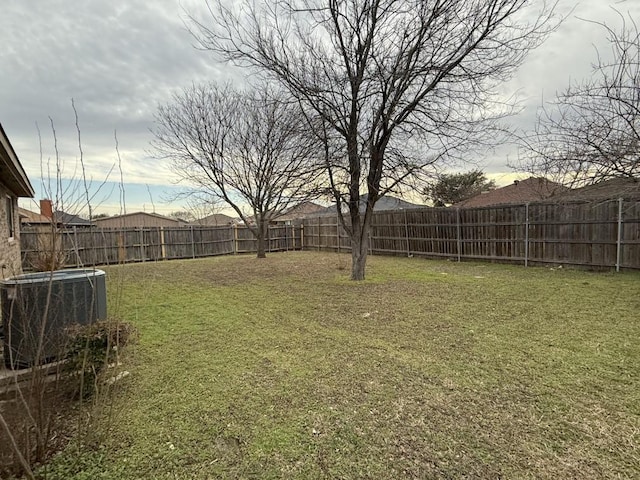 view of yard with central air condition unit and a fenced backyard