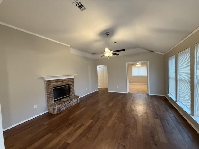 unfurnished living room with dark wood-style floors, visible vents, a fireplace, and ornamental molding