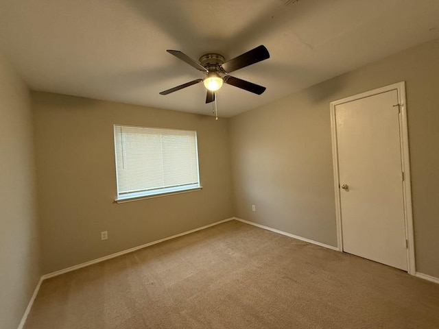 carpeted empty room with baseboards and ceiling fan