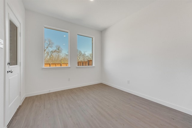 unfurnished room featuring light wood finished floors and baseboards