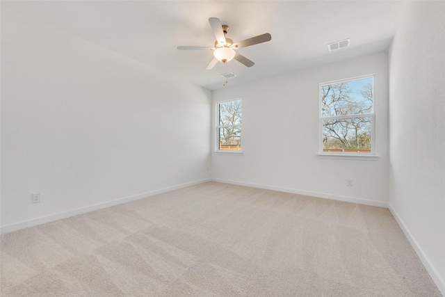 empty room featuring visible vents, baseboards, and light colored carpet