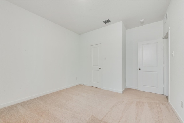 unfurnished bedroom with light carpet, visible vents, and baseboards