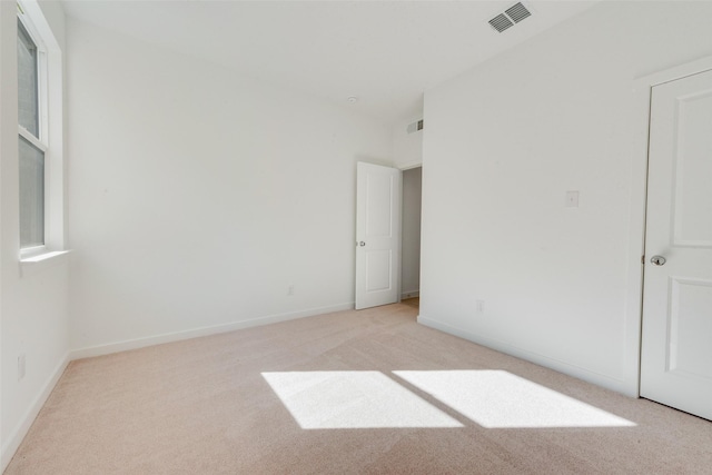 unfurnished bedroom featuring visible vents, baseboards, and light colored carpet