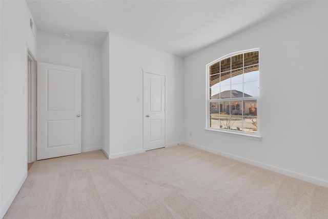 unfurnished bedroom featuring visible vents, carpet, and baseboards