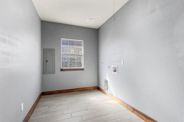 washroom with hookup for a washing machine, hookup for an electric dryer, laundry area, electric panel, and light wood-style floors