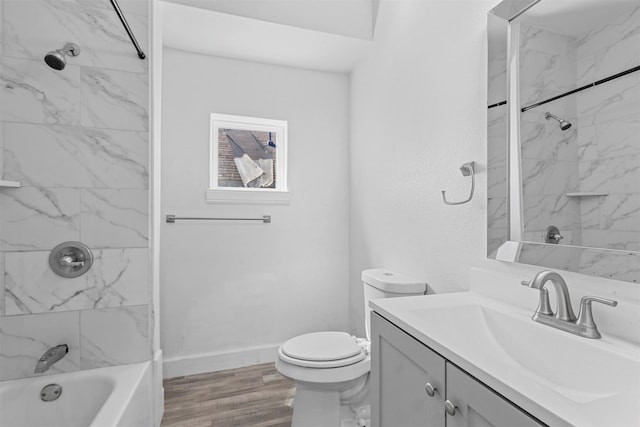 full bath featuring vanity, wood finished floors, baseboards, bathing tub / shower combination, and toilet