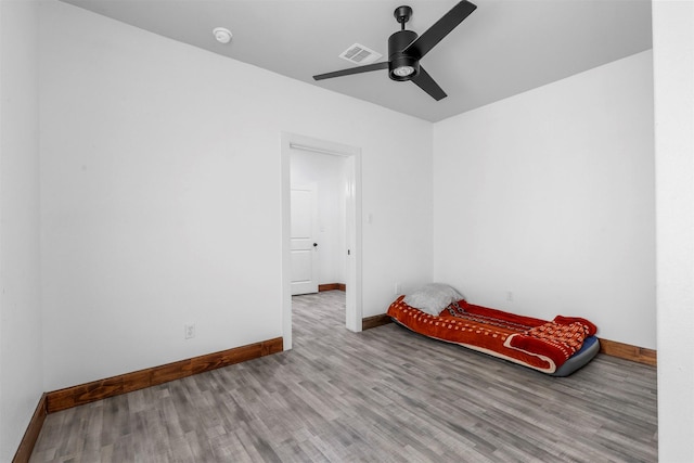 unfurnished bedroom with visible vents, baseboards, wood finished floors, and a ceiling fan