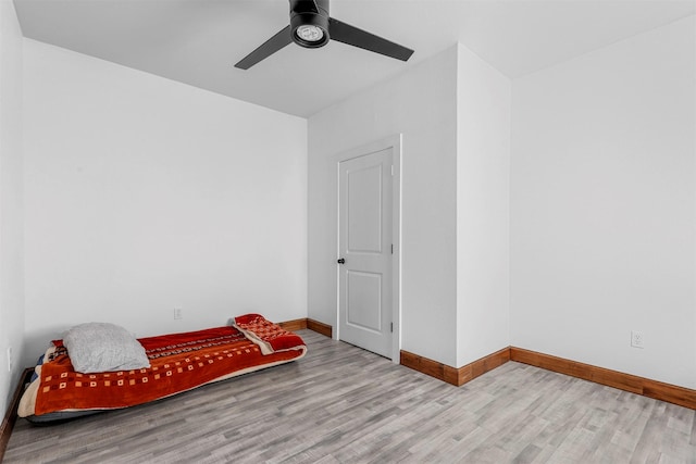 bedroom with ceiling fan, baseboards, and wood finished floors