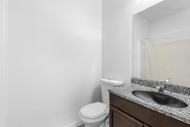 full bathroom featuring curtained shower, toilet, vanity, and baseboards