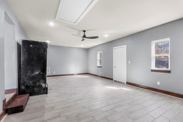 unfurnished living room featuring a ceiling fan, baseboards, light wood finished floors, attic access, and recessed lighting