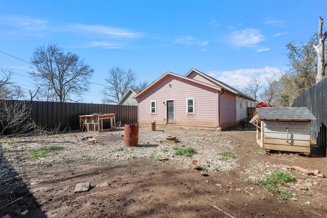 back of property with an outdoor structure and a fenced backyard