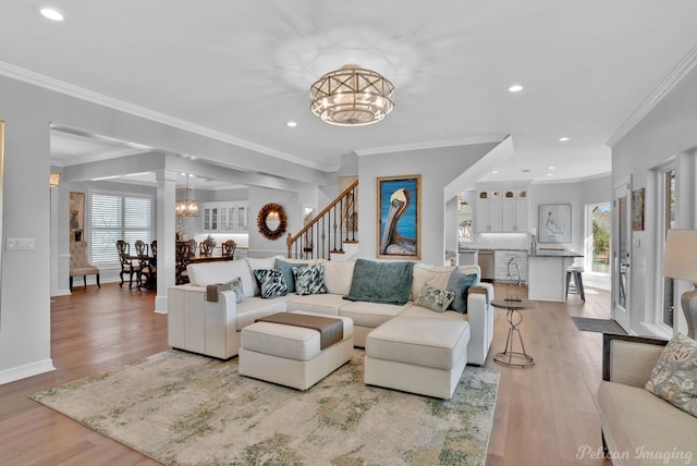 living area with plenty of natural light, an inviting chandelier, and light wood finished floors