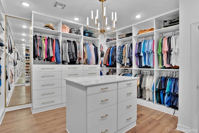 walk in closet featuring visible vents, light wood-style floors, and a chandelier