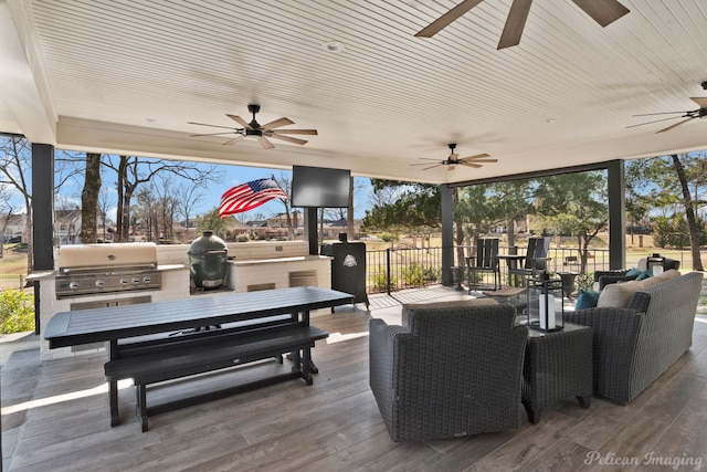 view of patio / terrace with an outdoor living space, grilling area, exterior kitchen, and a ceiling fan