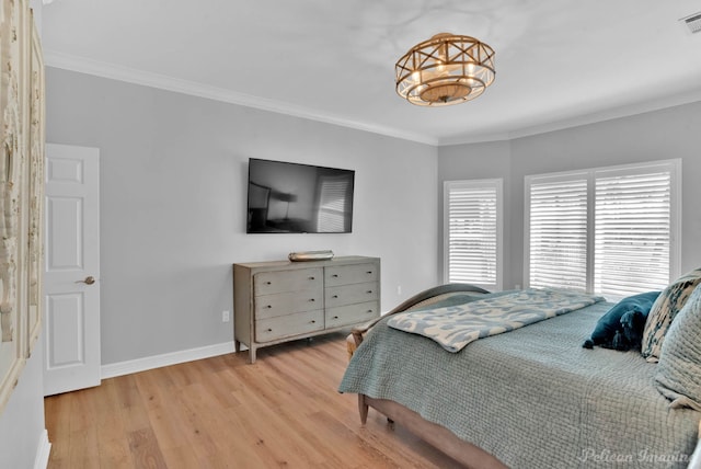 bedroom with crown molding, wood finished floors, visible vents, and baseboards