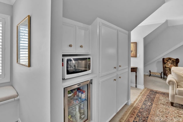 hall featuring baseboards, light colored carpet, and beverage cooler