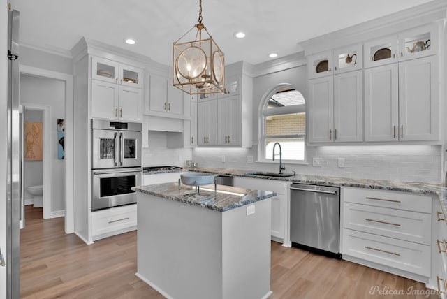 kitchen with white cabinetry, light wood-type flooring, appliances with stainless steel finishes, and a sink