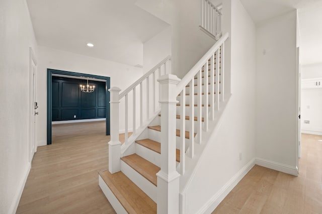 staircase featuring recessed lighting, baseboards, and wood finished floors