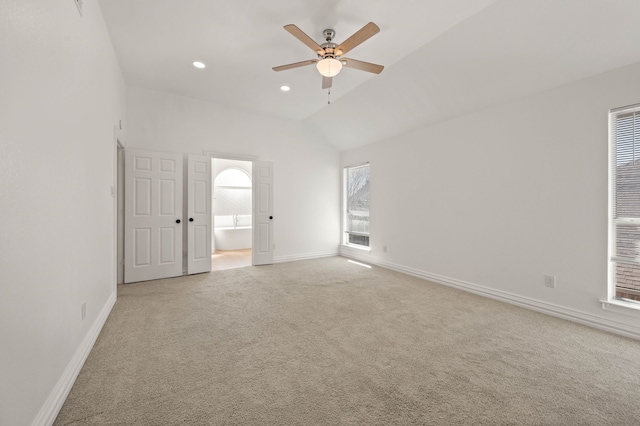 spare room featuring baseboards, lofted ceiling, recessed lighting, ceiling fan, and light carpet