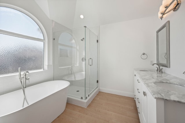 full bath featuring a freestanding tub, wood finished floors, a stall shower, and a sink