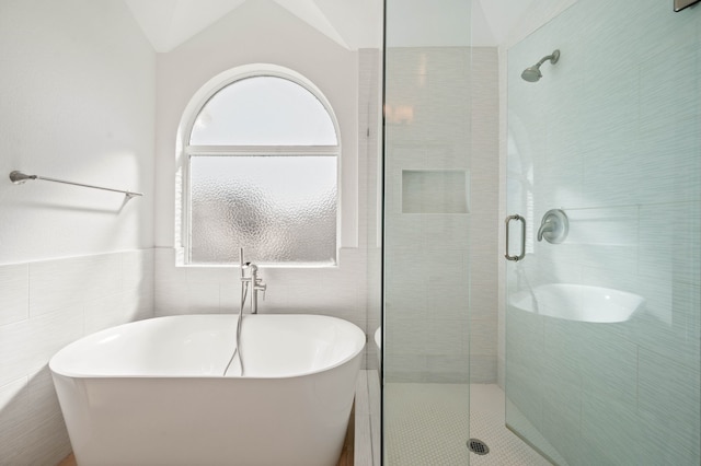 bathroom with tile walls and a stall shower