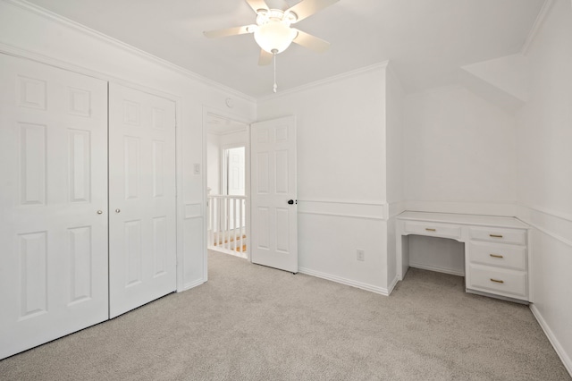 unfurnished bedroom featuring a ceiling fan, baseboards, carpet, ornamental molding, and a closet