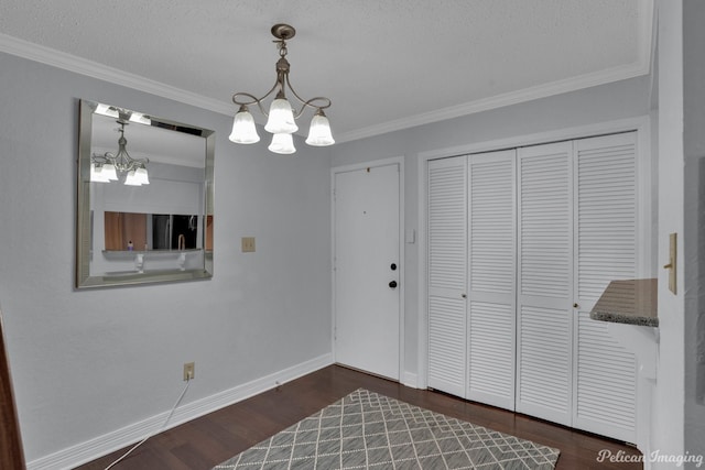 interior space with dark wood-style floors, an inviting chandelier, baseboards, and ornamental molding