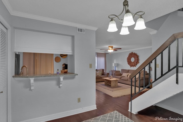 living room with stairs, crown molding, visible vents, and dark wood-style flooring