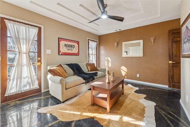 living area featuring a raised ceiling, ceiling fan, baseboards, and visible vents