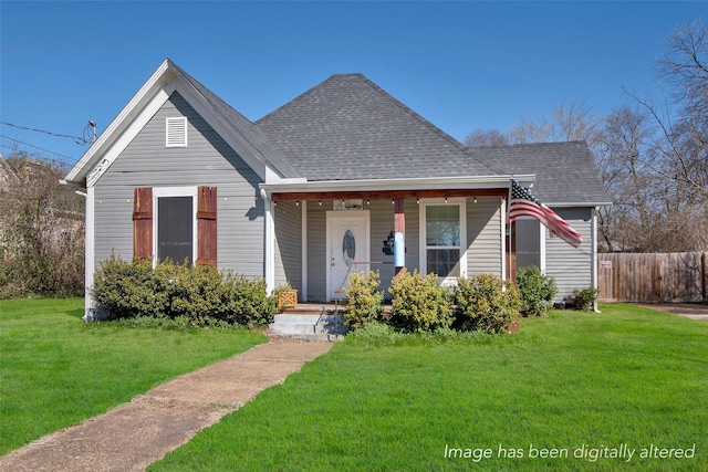 bungalow-style house with a front yard, fence, covered porch, and a shingled roof