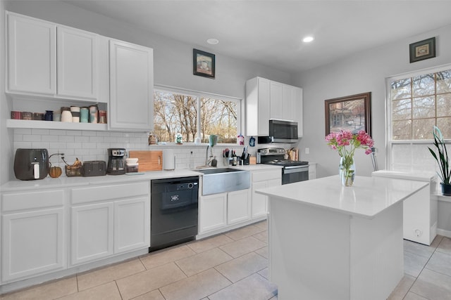 kitchen featuring a sink, tasteful backsplash, white cabinetry, stainless steel appliances, and light countertops