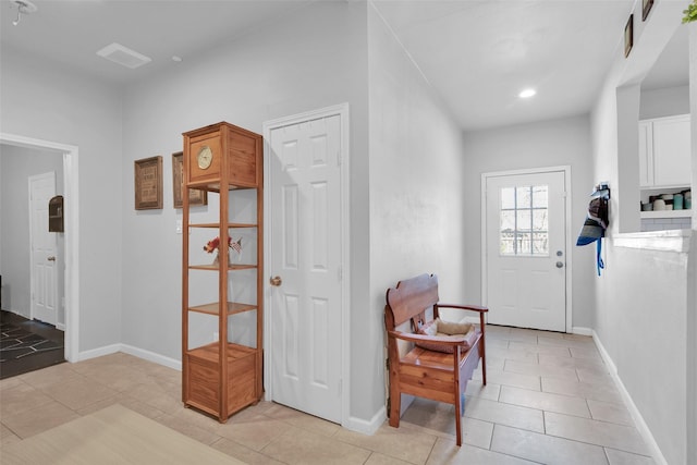 entryway with light tile patterned floors, recessed lighting, and baseboards