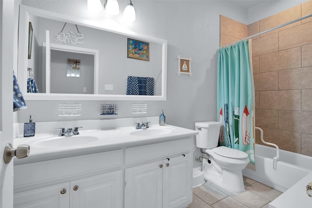 bathroom with a sink, toilet, double vanity, and tile patterned flooring