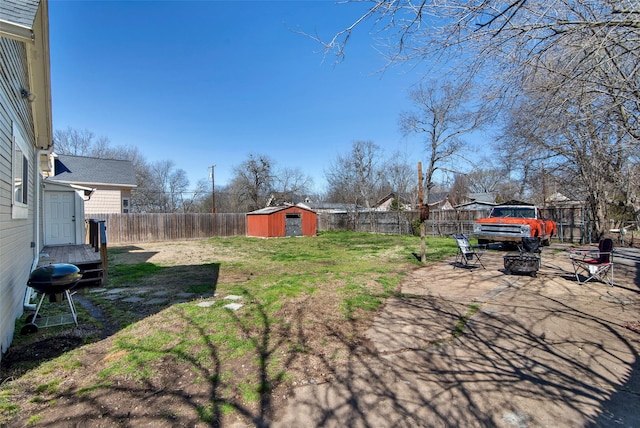 view of yard featuring an outdoor structure, a storage unit, a fenced backyard, and a patio area