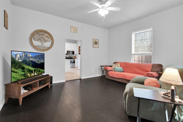 living area with baseboards, wood finished floors, and a ceiling fan