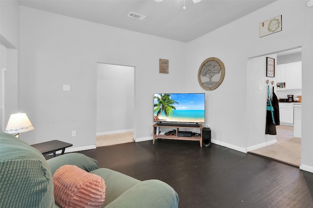 living area featuring visible vents, baseboards, and wood finished floors