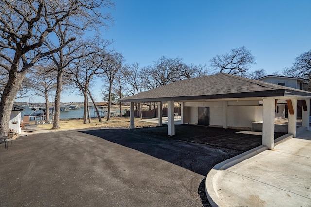 exterior space with a water view, a carport, and driveway