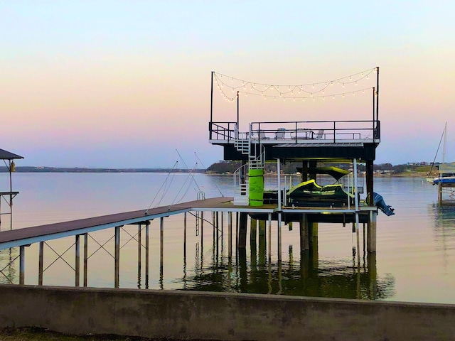 dock area with boat lift and a water view