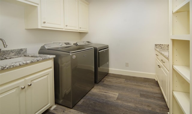 laundry area with a sink, dark wood-style floors, cabinet space, separate washer and dryer, and baseboards