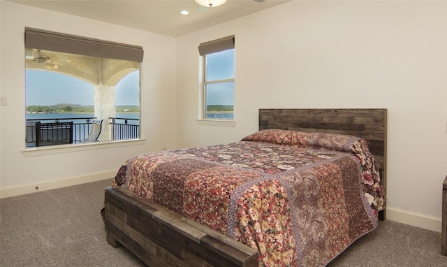 carpeted bedroom featuring recessed lighting, baseboards, and a water view