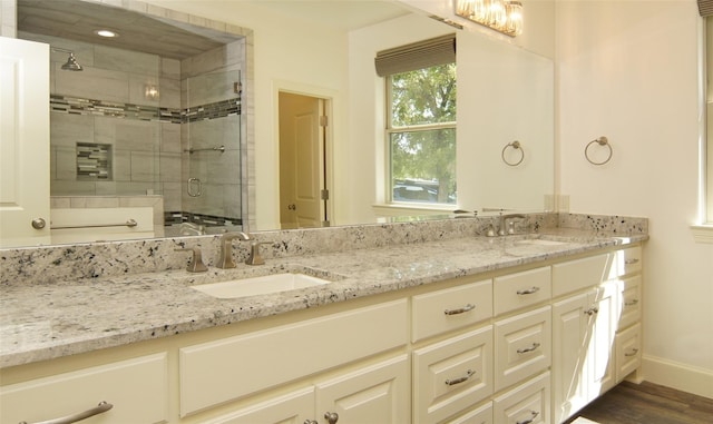 full bath with double vanity, a stall shower, and a sink