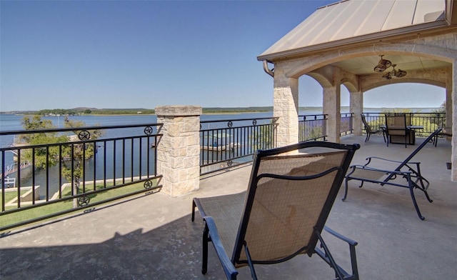 view of patio featuring a water view and a balcony