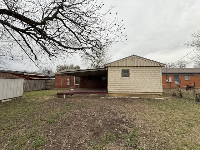 rear view of house featuring a shed, a yard, a fenced backyard, an outbuilding, and a deck