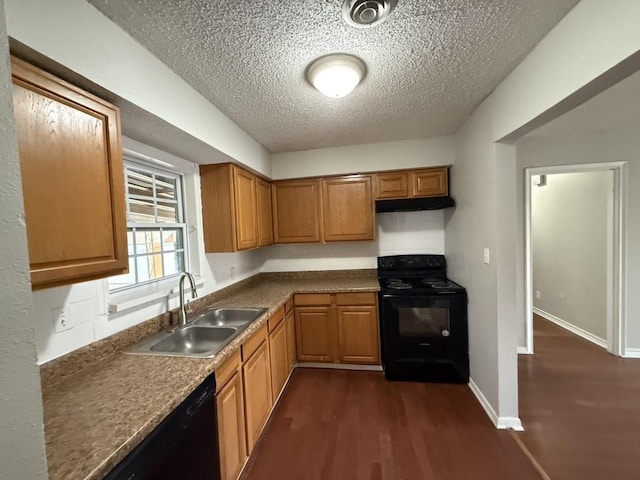 kitchen featuring baseboards, under cabinet range hood, dark wood finished floors, black appliances, and a sink