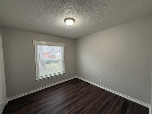 spare room with dark wood-style floors, baseboards, and a textured ceiling