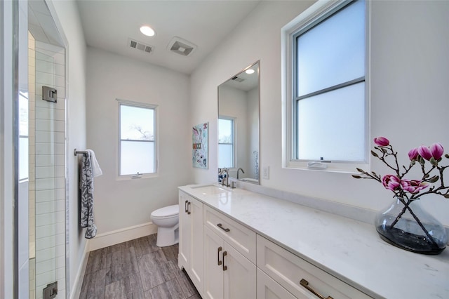 bathroom with visible vents, baseboards, toilet, and a shower stall