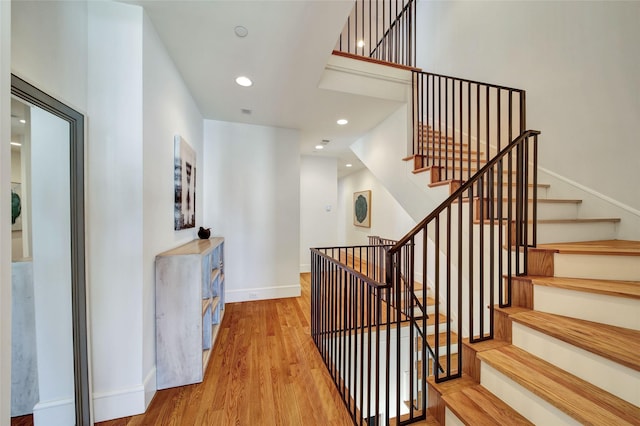 staircase featuring recessed lighting, baseboards, and wood finished floors