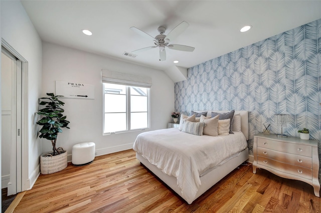 bedroom with wallpapered walls, baseboards, visible vents, and light wood finished floors